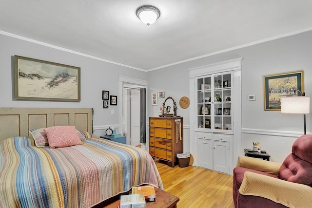 bedroom with ornamental molding and light wood-style flooring
