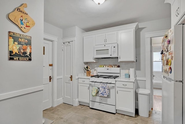 kitchen featuring white appliances, light countertops, decorative backsplash, and white cabinetry