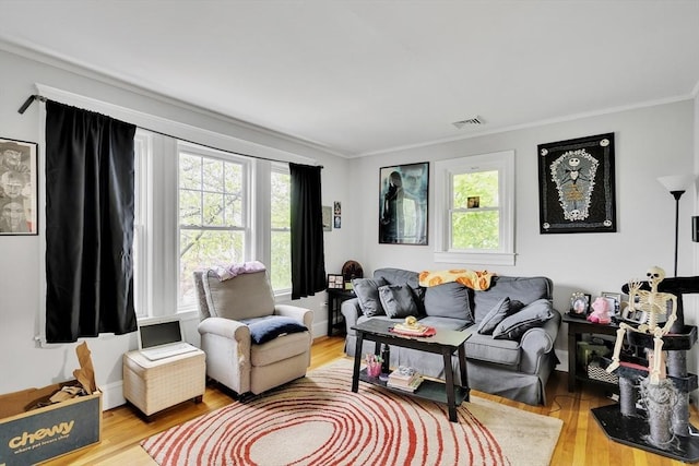 living room featuring plenty of natural light, wood finished floors, and crown molding