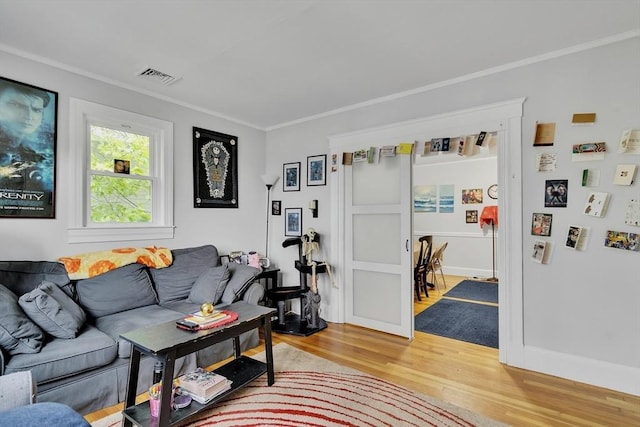 living room featuring light wood finished floors and crown molding