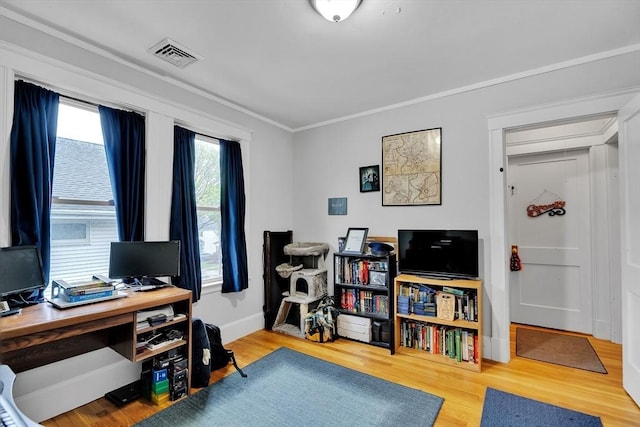office area featuring wood finished floors, crown molding, and baseboards