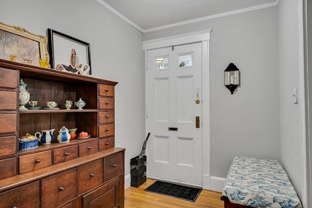 entrance foyer with light wood-type flooring, crown molding, and baseboards