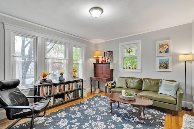 living area with crown molding, wood finished floors, and baseboards