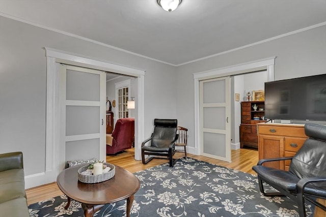 living area with ornamental molding, light wood-style flooring, french doors, and baseboards