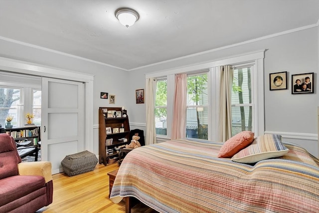 bedroom featuring wood finished floors and crown molding