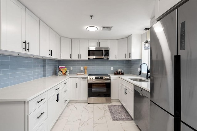 kitchen with sink, white cabinetry, backsplash, and stainless steel appliances