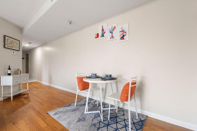 dining space with wood-type flooring