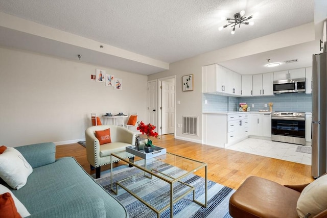 living room featuring light hardwood / wood-style flooring and a textured ceiling