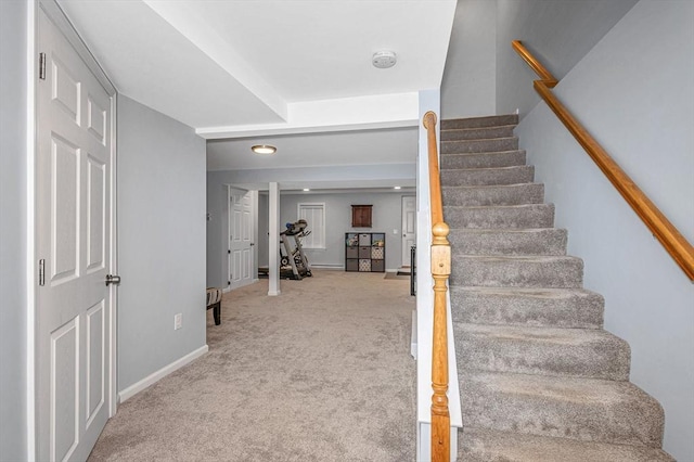 stairway featuring carpet floors and baseboards