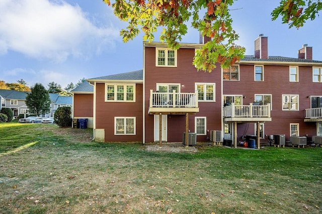 back of property with a lawn and central AC