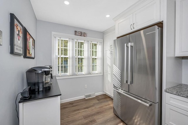 kitchen featuring baseboards, visible vents, dark wood-style floors, white cabinetry, and high end fridge