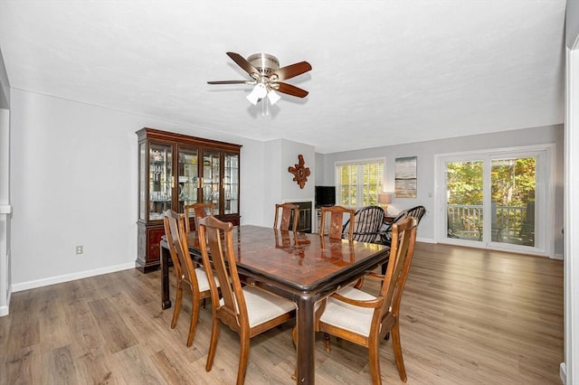 dining room featuring light wood-style floors, ceiling fan, and baseboards