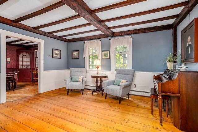 9 Eaton St, Gardner, MA 01440 - living area featuring a baseboard heating unit, a wainscoted wall, light wood finished floors, and beam ceiling