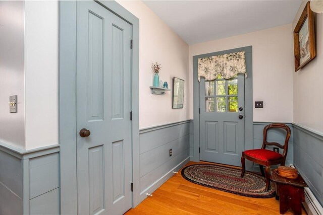 9 Eaton St, Gardner, MA 01440 - entryway with a baseboard radiator, wainscoting, and wood finished floors