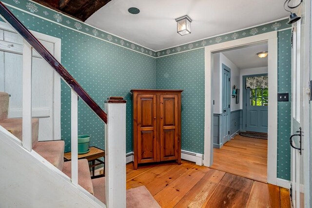 9 Eaton St, Gardner, MA 01440 - entryway featuring wood-type flooring, a baseboard radiator, wallpapered walls, stairway, and baseboards