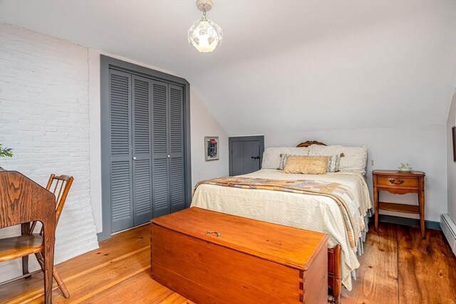 9 Eaton St, Gardner, MA 01440 - bedroom with wood finished floors, lofted ceiling, a closet, and brick wall