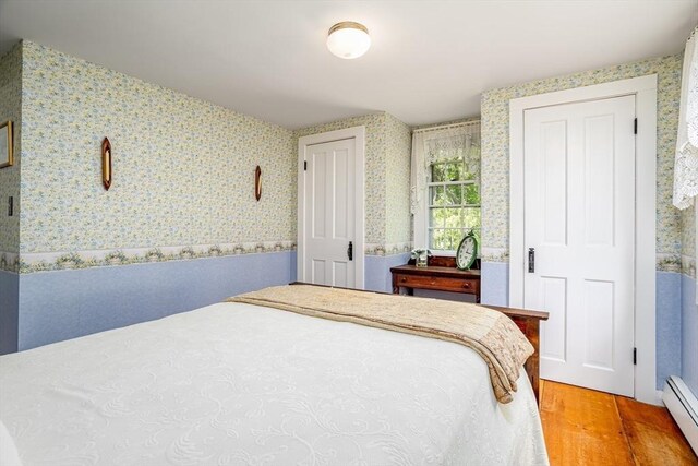9 Eaton St, Gardner, MA 01440 - bedroom featuring wallpapered walls, wood finished floors, and a baseboard heating unit