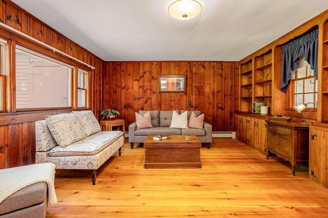 9 Eaton St, Gardner, MA 01440 - living room featuring a baseboard heating unit, wood walls, and light wood-style flooring