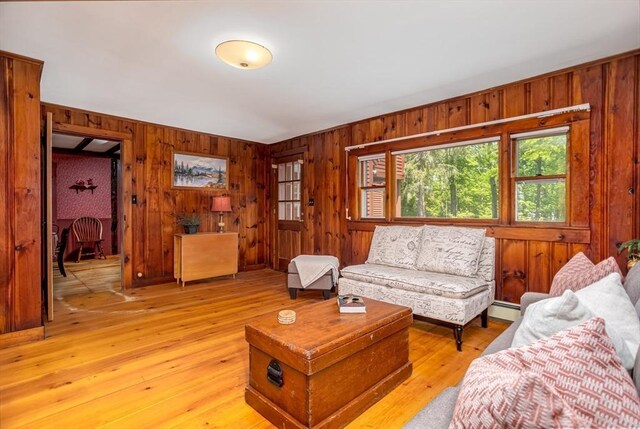 9 Eaton St, Gardner, MA 01440 - living room with wooden walls, light wood-style flooring, and a baseboard heating unit
