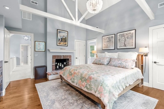 1 Crooked Ln, Manchester, MA 01944 - bedroom with high vaulted ceiling, wood finished floors, a chandelier, and a brick fireplace