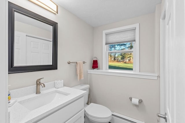 bathroom featuring toilet, vanity, and a baseboard radiator