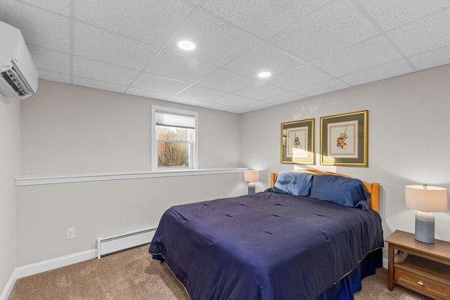 bedroom with a baseboard heating unit, carpet, and an AC wall unit