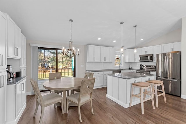 kitchen featuring stainless steel appliances, white cabinets, tasteful backsplash, and a kitchen island