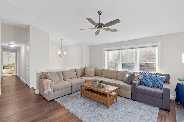 living room featuring wood-type flooring and ceiling fan with notable chandelier