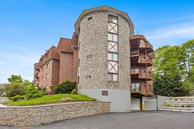 215 Thomas Burgin Pkwy Unit H13, Quincy, MA 02169 - view of property with an attached garage and asphalt driveway