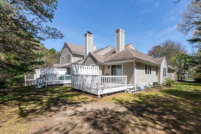 12 Kettle Ln Unit 31, Mashpee, MA 02649 - back of property with a wooden deck, a lawn, a chimney, and a shingled roof