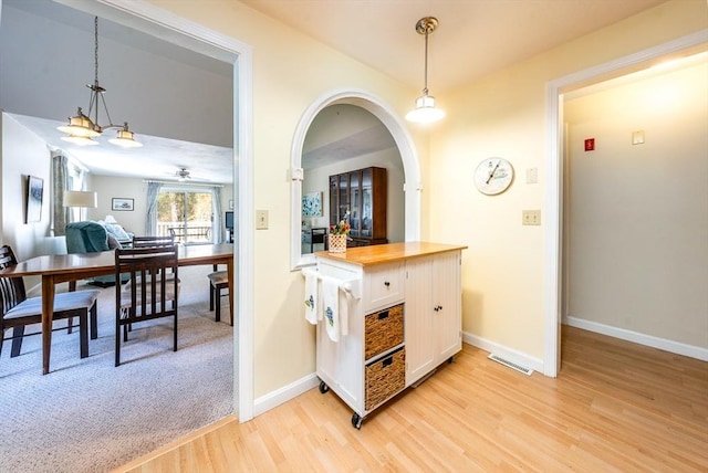 12 Kettle Ln Unit 31, Mashpee, MA 02649 - kitchen featuring light wood finished floors, wooden counters, white cabinetry, and decorative light fixtures