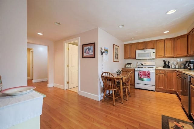 kitchen with white appliances, light wood-type flooring, brown cabinets, light countertops, and tasteful backsplash