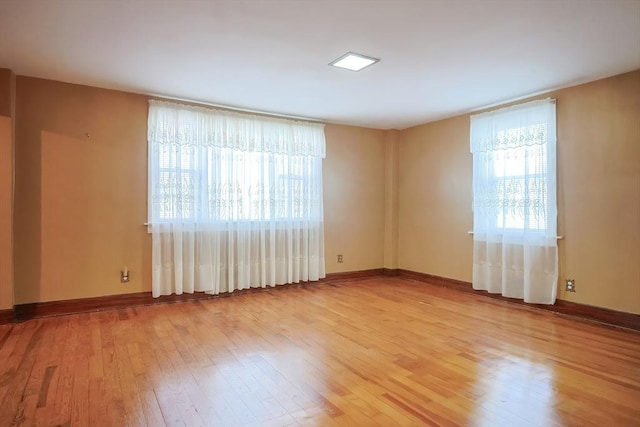 spare room featuring light wood-style flooring and baseboards