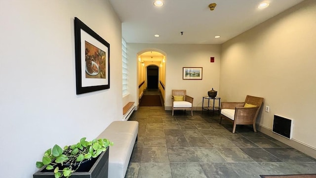 66 Winchester St Phb, Phb, Brookline, MA 02446 - living area featuring arched walkways, a baseboard heating unit, recessed lighting, baseboards, and dark stone finish flooring