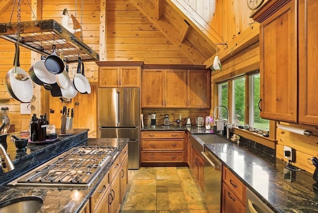 4 Paddock Rd, Rutland, MA 01543 - kitchen with appliances with stainless steel finishes, wooden walls, a sink, brown cabinets, and light stone finish floors