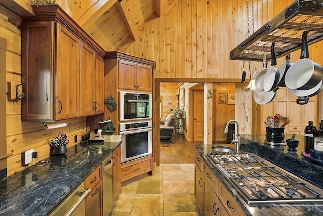 4 Paddock Rd, Rutland, MA 01543 - kitchen featuring stainless steel appliances, wood walls, a sink, brown cabinetry, and light tile patterned floors