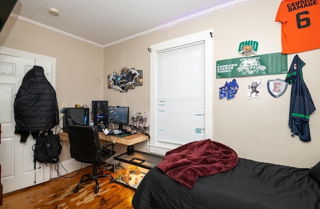 bedroom with hardwood / wood-style floors and crown molding