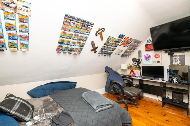 bedroom with wood-type flooring and vaulted ceiling