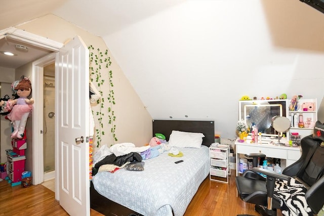 bedroom with wood-type flooring and vaulted ceiling