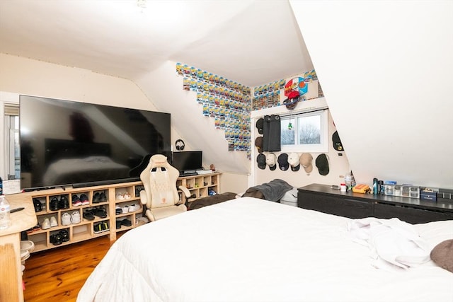 bedroom with hardwood / wood-style floors and lofted ceiling