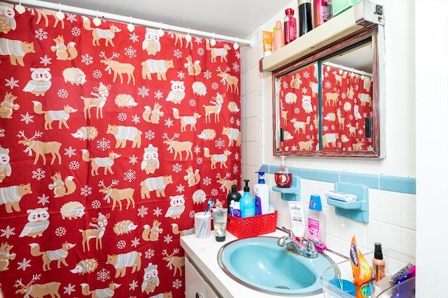 bathroom featuring vanity and tile walls