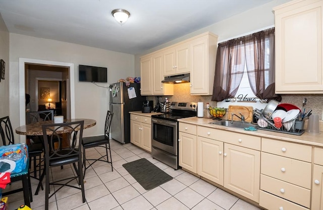 kitchen with appliances with stainless steel finishes, tasteful backsplash, sink, cream cabinets, and light tile patterned flooring