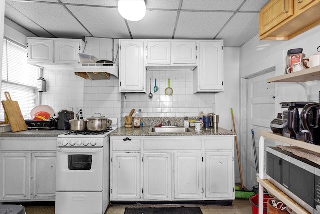 kitchen with white gas range, white cabinetry, a drop ceiling, sink, and custom exhaust hood