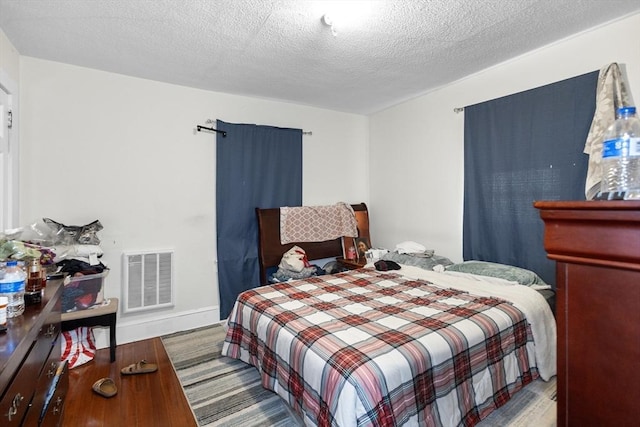 bedroom with light hardwood / wood-style flooring and a textured ceiling