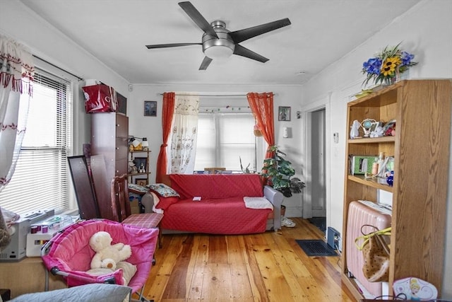 sitting room with ceiling fan, light hardwood / wood-style flooring, and radiator heating unit