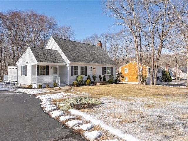 cape cod house with a shingled roof, a chimney, and a porch