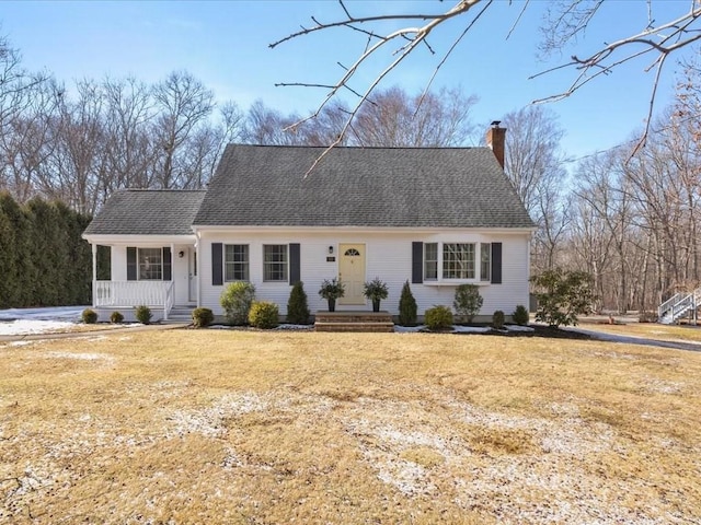 cape cod house featuring a shingled roof, a chimney, and a front yard