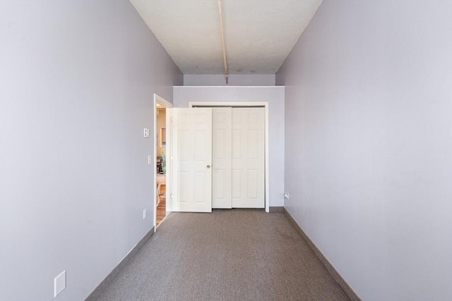 hallway featuring carpet and baseboards