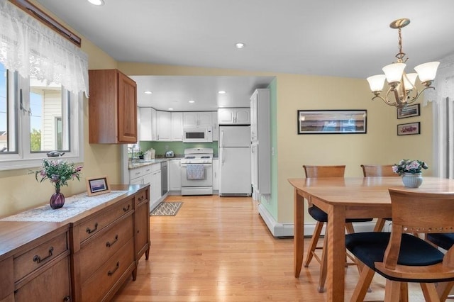5 I St Unit 2, Newburyport, MA 01950 - kitchen featuring white appliances, light wood-style flooring, a chandelier, light countertops, and decorative light fixtures