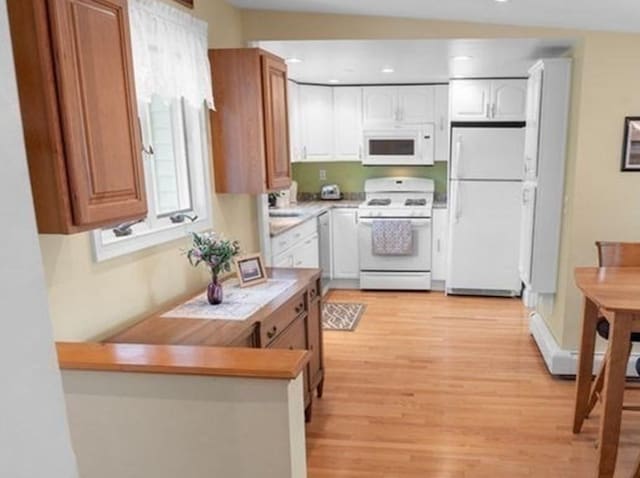 5 I St Unit 2, Newburyport, MA 01950 - kitchen with white appliances, light wood finished floors, light countertops, a peninsula, and recessed lighting